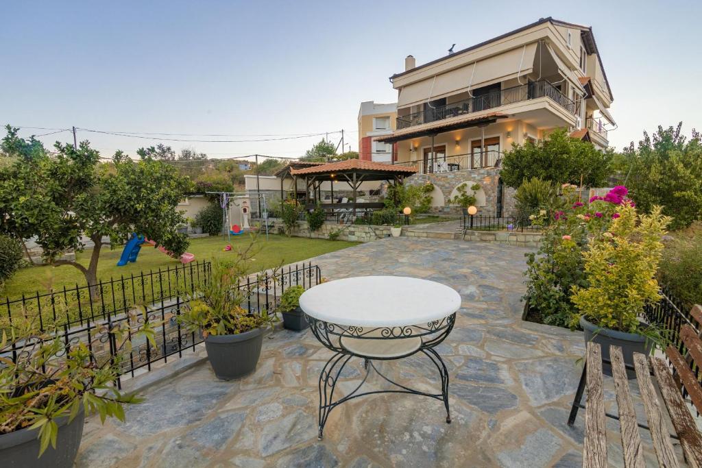 a patio with a table and chairs and a building at Villa Galani Agios Stefanos in Volos