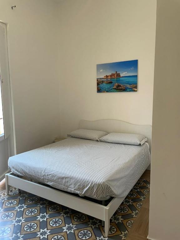 a bed in a room with a picture on the wall at Il Canto del Gallo in Crotone