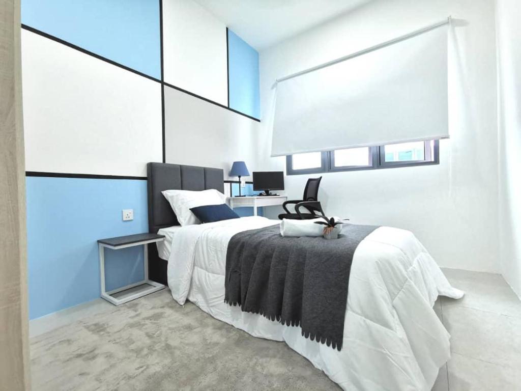a white bedroom with a bed and a desk at Meritus Seaview Apartment in Perai