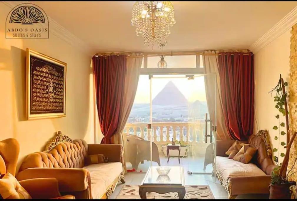 a living room with a couch and a large window at Pyramids Suite in Cairo