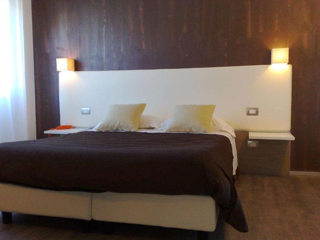 a bedroom with a large bed with two pillows at Hotel Toscana in Figline Valdarno