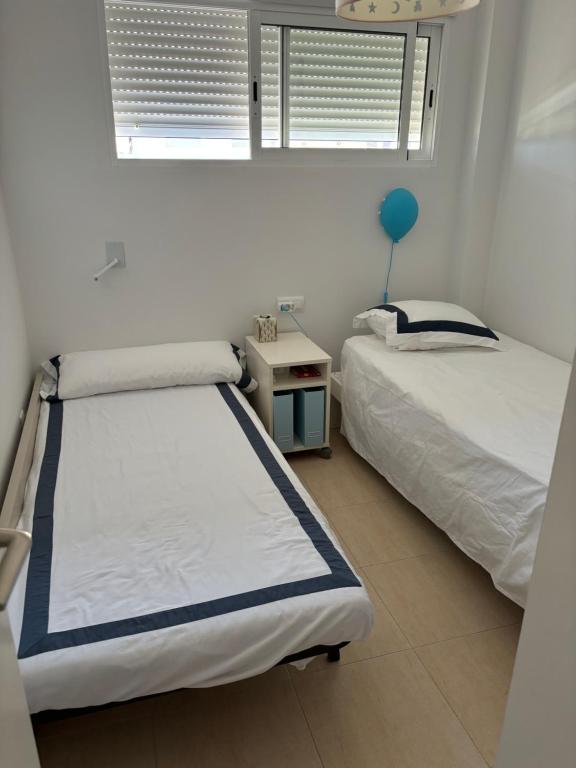 a bedroom with two beds and a table with a blue balloon at Casita Azul in Moncófar