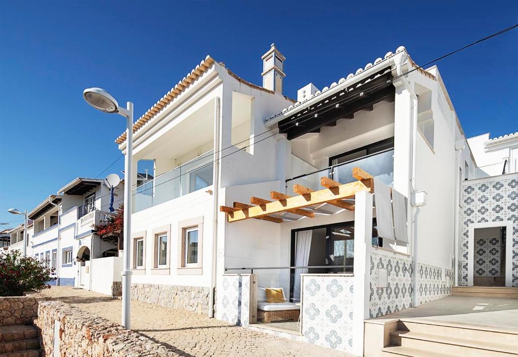 a white house with a street light in front of it at Casas da Praia by Sevencollection in Salema