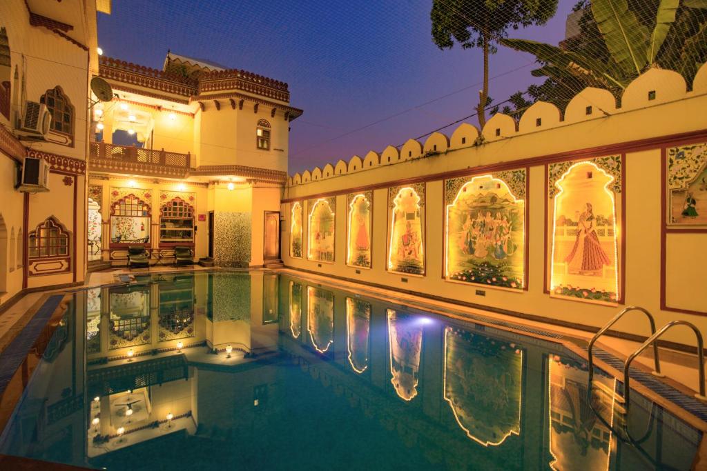 a villa with a swimming pool at night at Umaid Bhawan - A Heritage Style Boutique Hotel in Jaipur