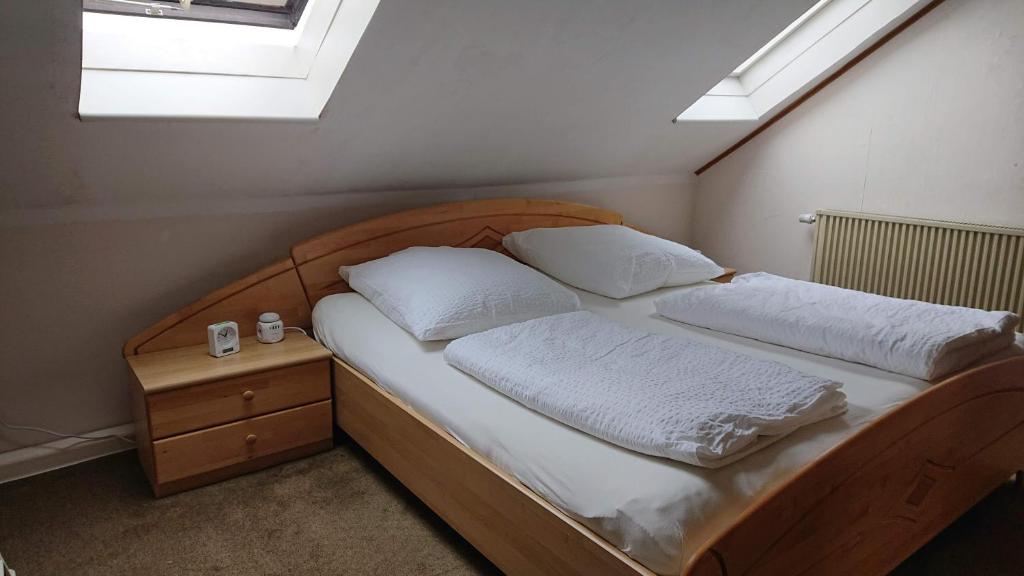a bed with two pillows and a night stand in a bedroom at Ferienwohnung in Ländliche Gegend die zum Verweilen einlädt in Wachenroth