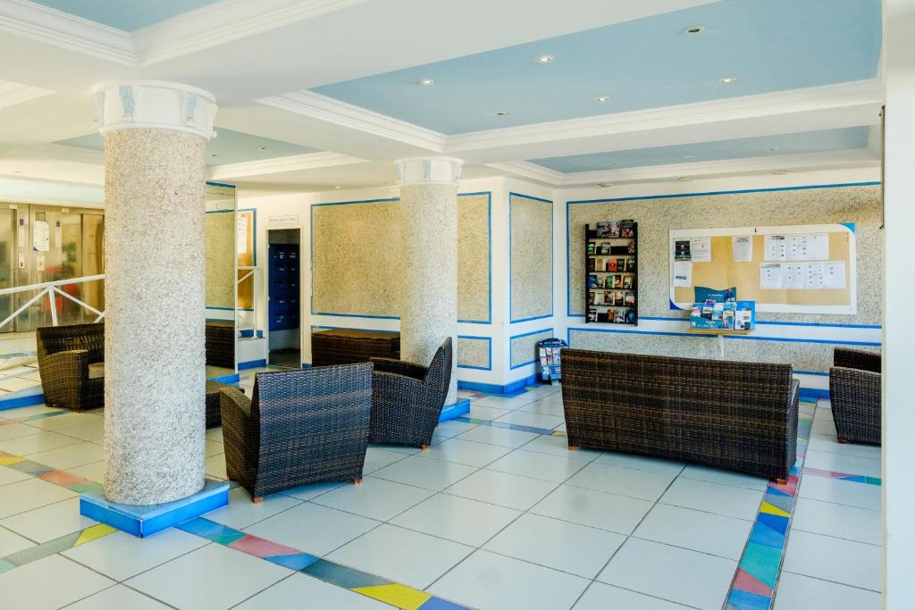 a lobby with chairs and a bar in a restaurant at Résidence Pierre & Vacances l'Ange Gardien in Villefranche-sur-Mer