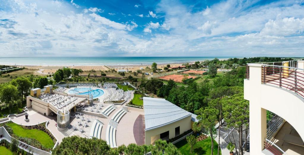 an aerial view of a resort with a pool and the ocean at Laguna Park Hotel 4Superior in Bibione