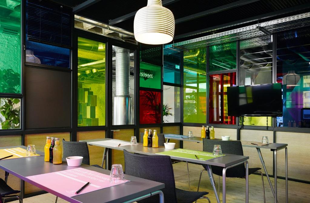 a restaurant with tables and chairs and a flat screen tv at 25hours Hotel Bikini Berlin in Berlin