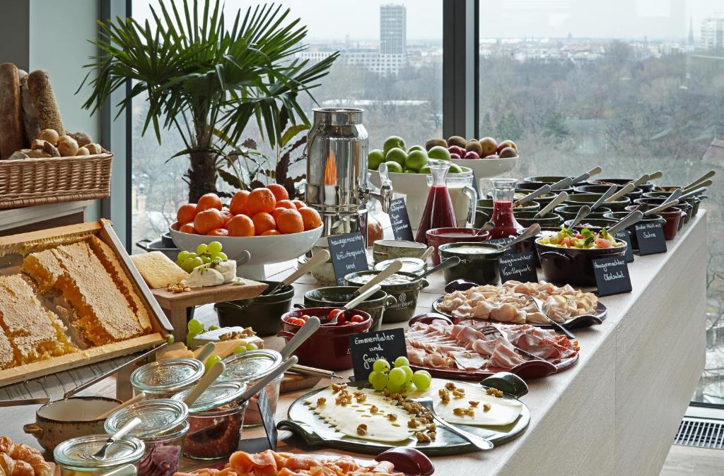 a buffet of food on a table with a view at 25hours Hotel Bikini Berlin in Berlin