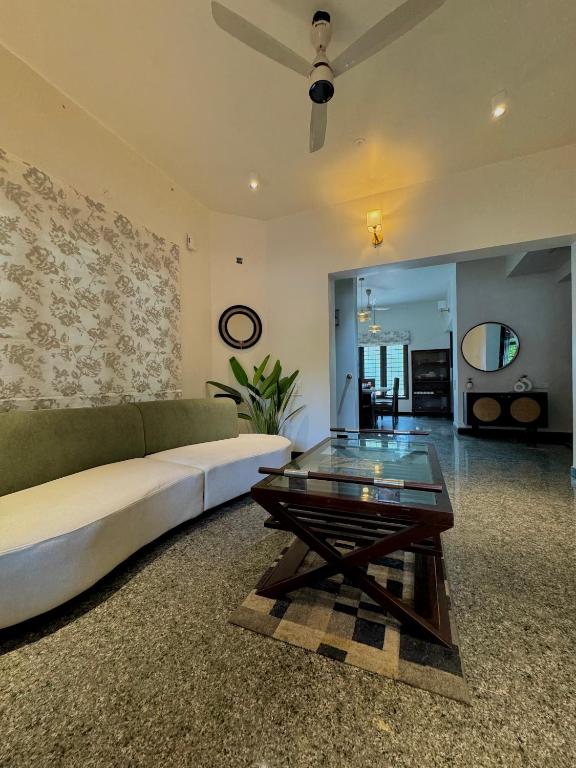 a living room with a couch and a glass table at Idam Na Mama - Luxury Homestay by HomeSlice in Bangalore