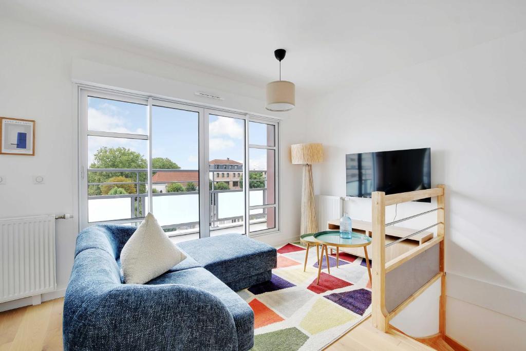 un salon avec un canapé bleu et une télévision dans l'établissement Lovely Duplex -4BR-8P- Nogent-sur-Marne, à Nogent-sur-Marne