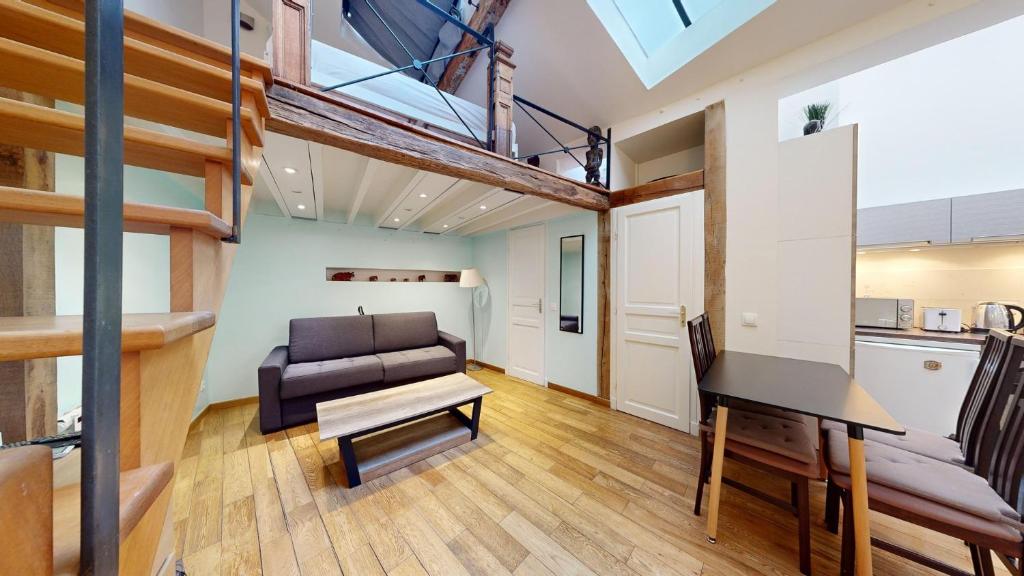 Cet appartement loft dispose d'un canapé et d'un piano. dans l'établissement Bluestay 131 - Charmant appartement à Paris, à Paris