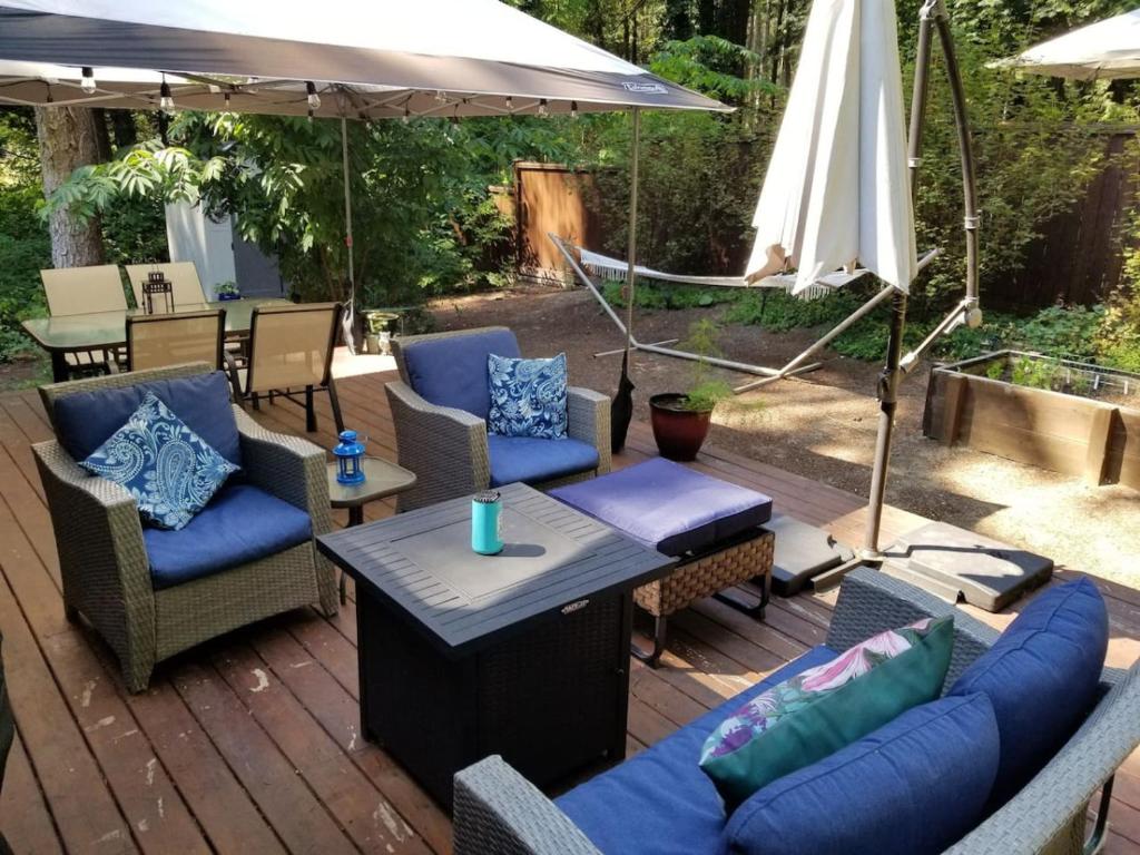 eine Terrasse mit Stühlen, einem Tisch und einem Sonnenschirm in der Unterkunft The Cottage on Claire in Point Roberts