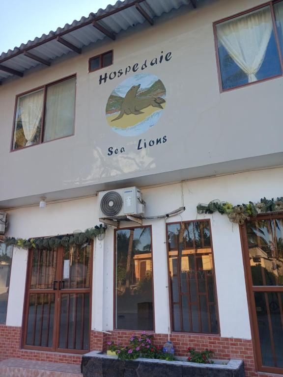 a building with a sign that reads hognsics sea lions at Hospedaje SEA LIONS in Puerto Villamil