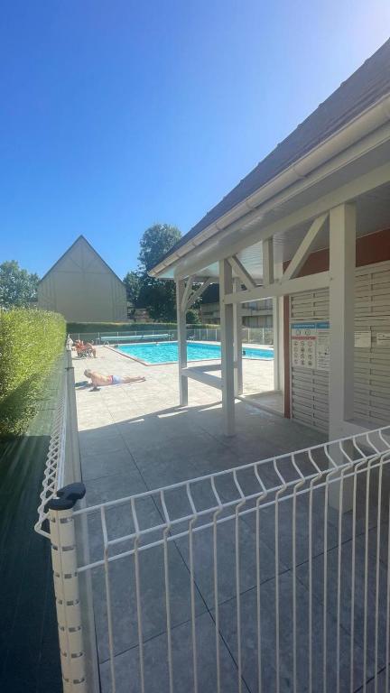 une clôture en face d'une piscine dans l'établissement Appartement - Résidence Vacances calme et tout confort, à Touques