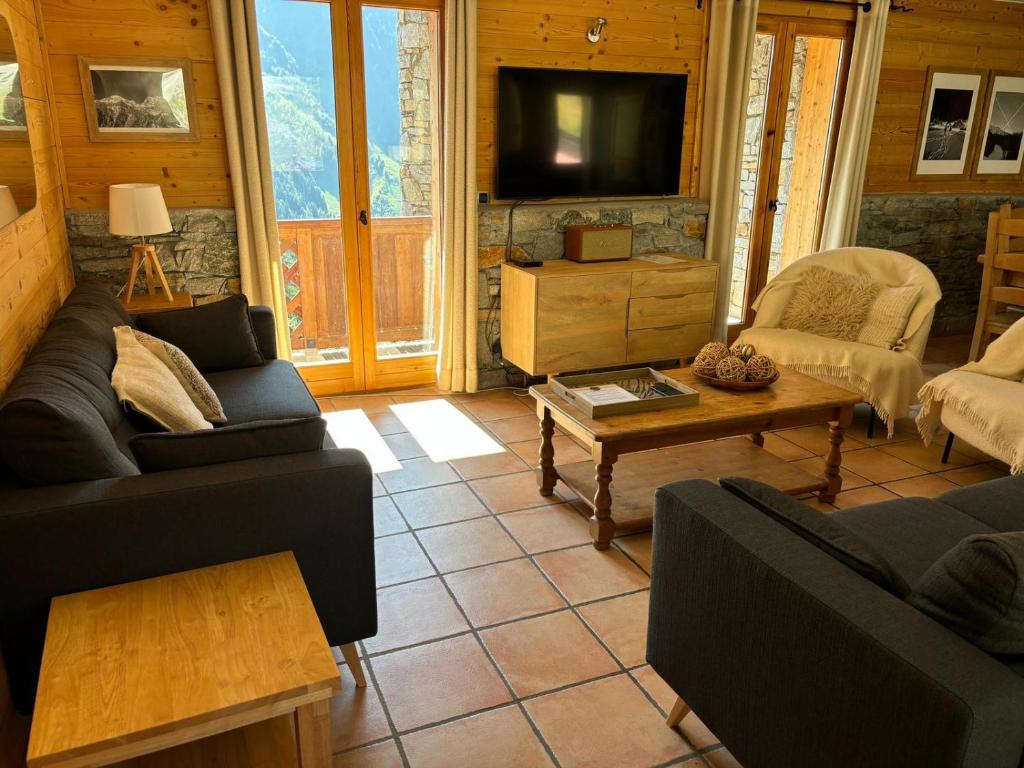 un salon avec deux canapés et une télévision dans l'établissement Montagnard - 4 bedroom apartment with stunning views, à Sainte-Foy-Tarentaise