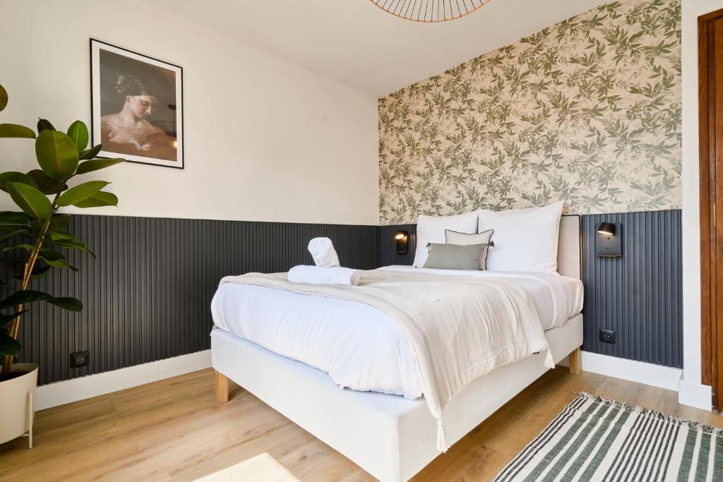 - une chambre avec un lit blanc et un papier peint floral dans l'établissement Appartement une chambre proche métro, à Lille