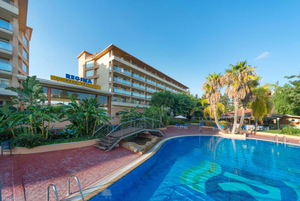 un hotel con piscina frente a un edificio en 4R Gran Regina, en Salou