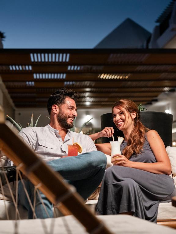 a man and a woman sitting in chairs laughing at MYND Yaiza in Playa Blanca