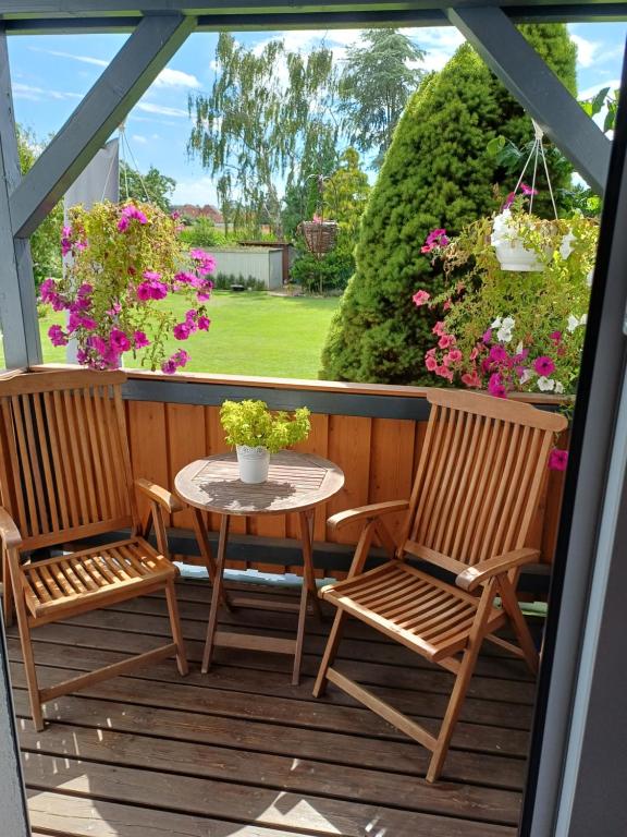 two chairs and a table on a porch with flowers at Ferienwohnung Marienberg in Nordstemmen