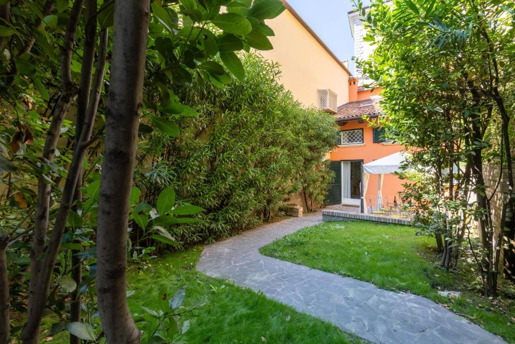 a garden with a walkway leading to a house at BolognaRoomscom - Isaia Garden Private Garden Spa Bath in Bologna