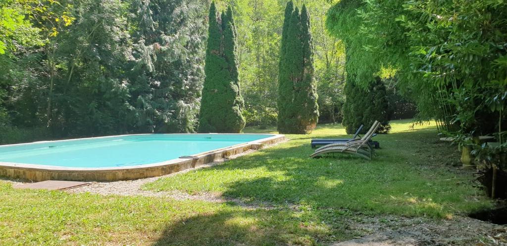 - une piscine dans une cour avec un banc et des arbres dans l'établissement La Maison De L'Ecrivain, à La Bastide-lʼÉvêque