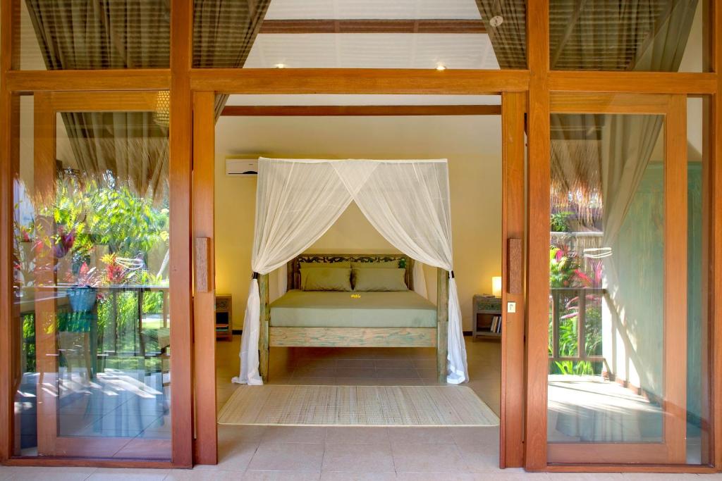 a bed with a canopy in a room at Sasa Bali Villas in Seminyak