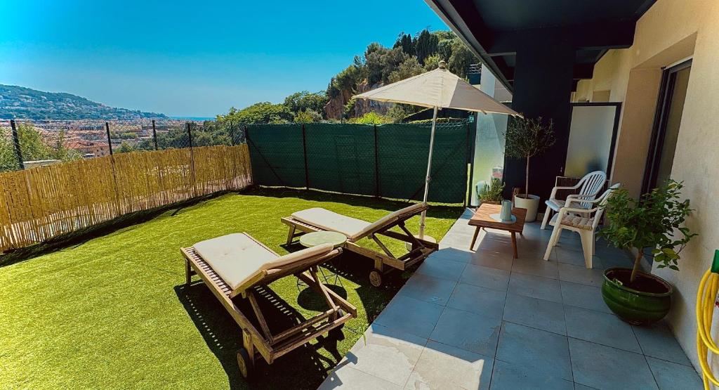 d'une terrasse avec des chaises et un parasol sur la pelouse. dans l'établissement Art Studio Nice, à Nice