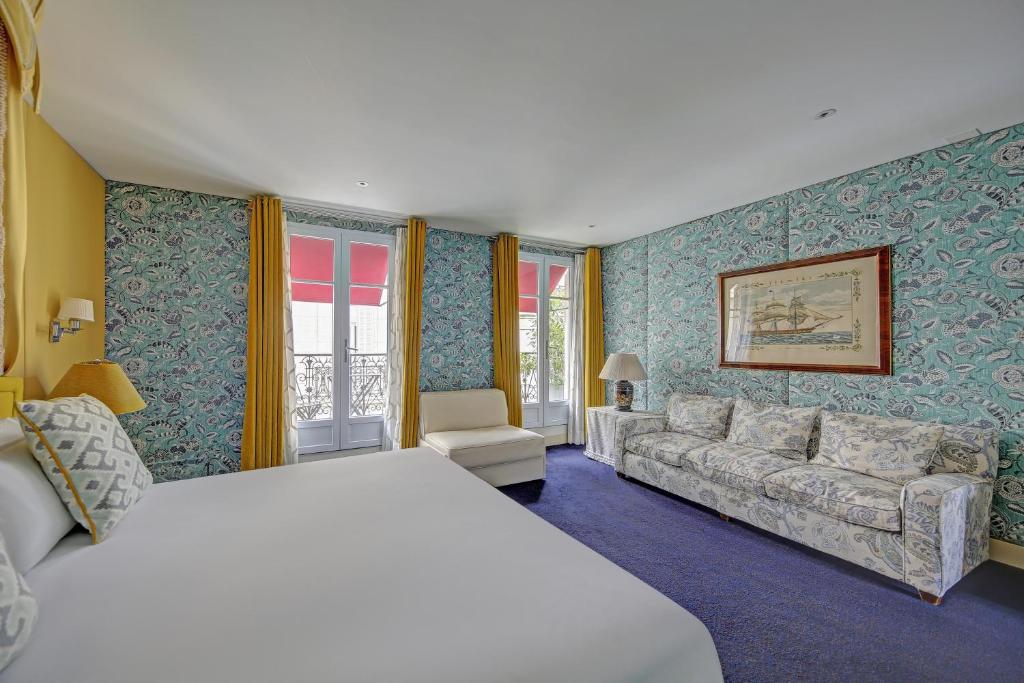 een hotelkamer met een bed en een bank bij Chalgrin Boutique Hotel in Parijs