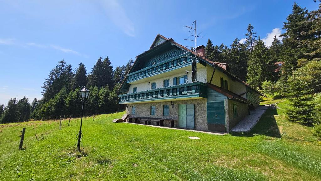 a house on a hill in a grassy field at Apartma Jurček Rogla in Rakovec