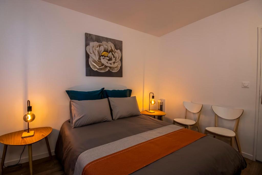 - une chambre avec un lit, 2 tables et des chaises dans l'établissement Appartement cosy aux coeur de Paris - 10 pers, à Paris