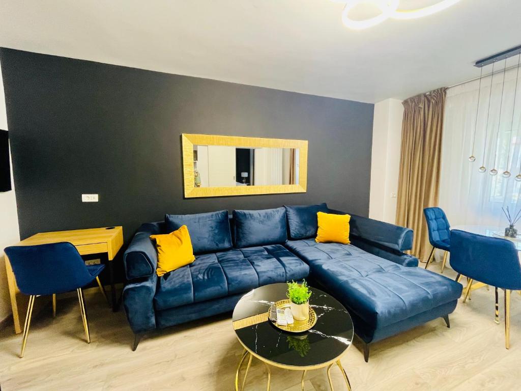 ブカレストにあるMetropole Apartments Central Cityの青いソファとテーブルのあるリビングルーム