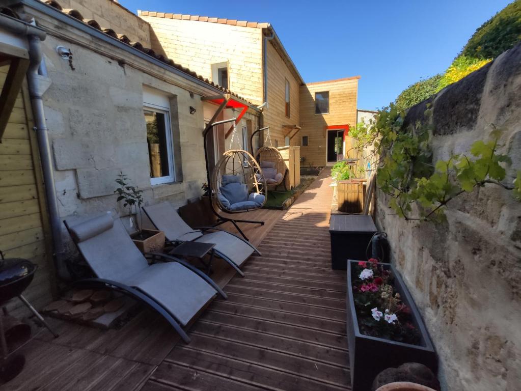 a patio with chairs and flowers on the stairs at Villa Pauill'Art in Pauillac