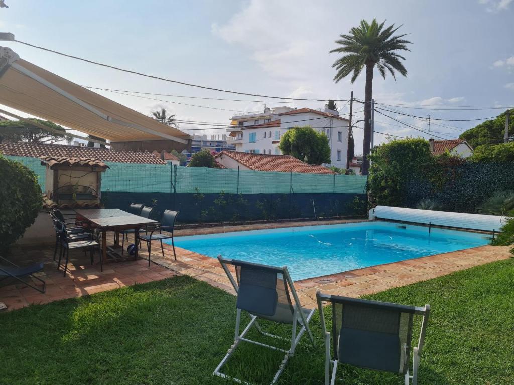 - une piscine avec des chaises et une table dans la cour dans l'établissement Villa avec piscine privée à Juan Les Pins, à Juan-les-Pins
