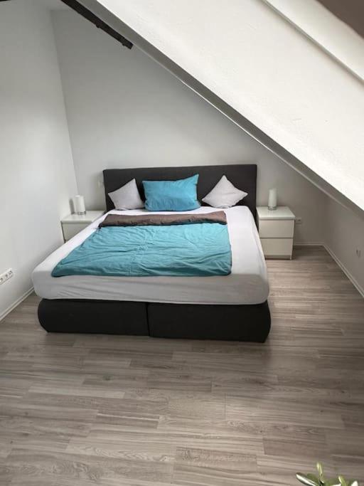 a bedroom with a large bed with blue pillows at Panoramablick in Litzendorf in Litzendorf