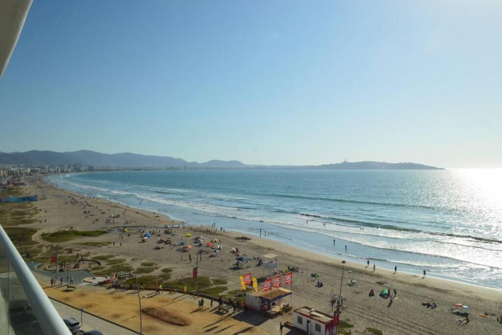 une plage avec beaucoup de monde et l'océan dans l'établissement Depto frente a la playa en avenida del Mar Se permiten mascotas Mac07, à La Serena