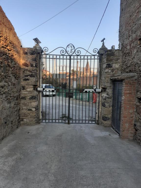 an iron gate in a stone building with a car parked behind it at La tenuta Moscatella a 200m dal mare in Schisò