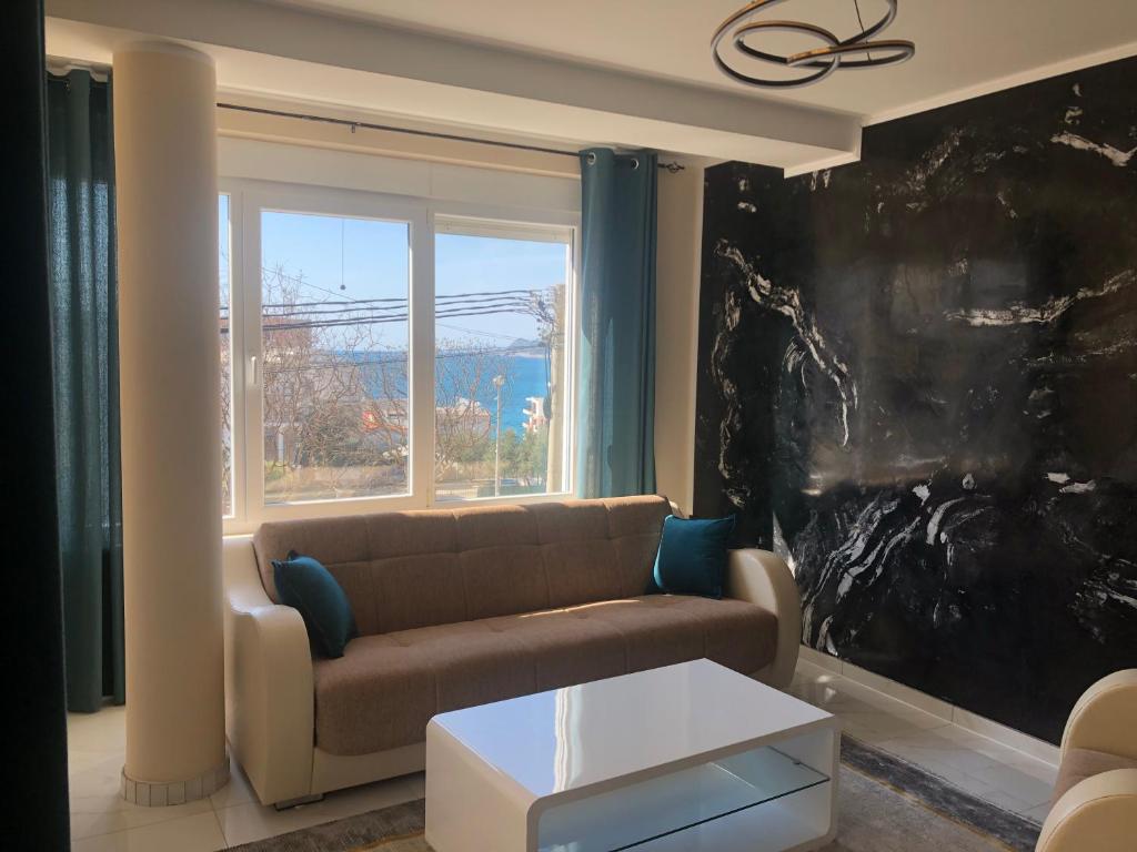Una sala de estar con un sofá y una ventana grande. en BonMare.apt4, en Dobra Voda
