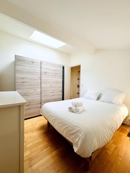 - une chambre dotée d'un grand lit blanc avec deux tasses dans l'établissement Coeur de Paris - Paris 1er, à Paris