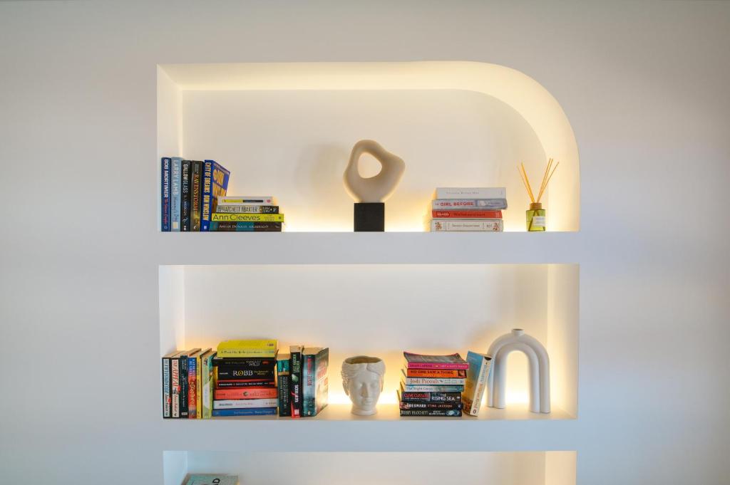 two shelves with books and a faucet and a sink at Yperia Hotel in Aegiali