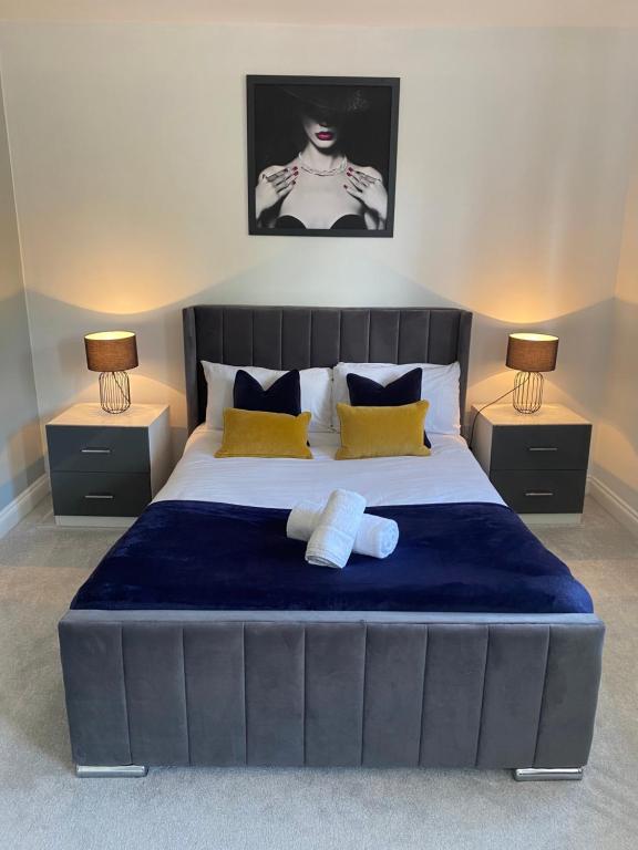 a bedroom with a large bed with two night stands at The Heathers - Spacious 3 Bed, Home from Home in Burton in Burton upon Trent