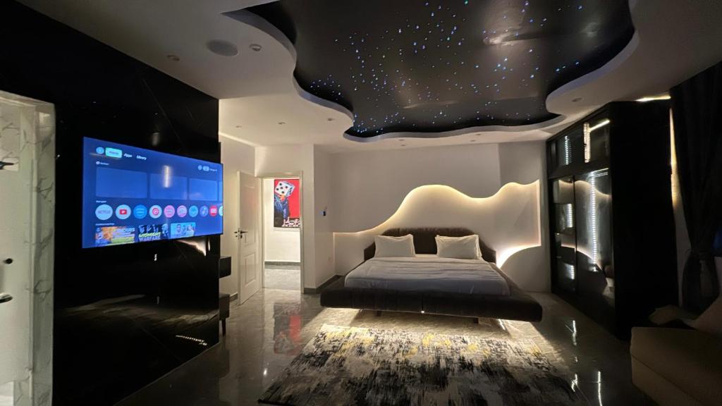 a bedroom with a bed and a flat screen tv at Luxury Two Bedroom Apartment Victoria Island in Lagos