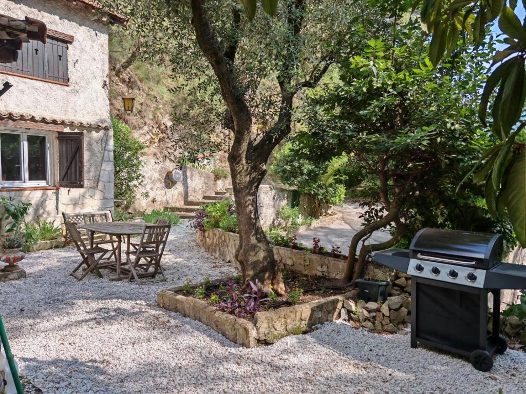 une table et un grill à côté d'un arbre dans l'établissement Maison dans l'arrière pays niçois entre mer et montagne, à Tourrette-Levens