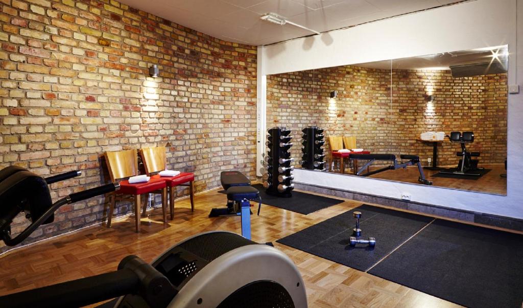 - une salle de sport dotée d'un mur en briques et de nombreux équipements dans l'établissement The More Hotel Mazetti, à Malmö