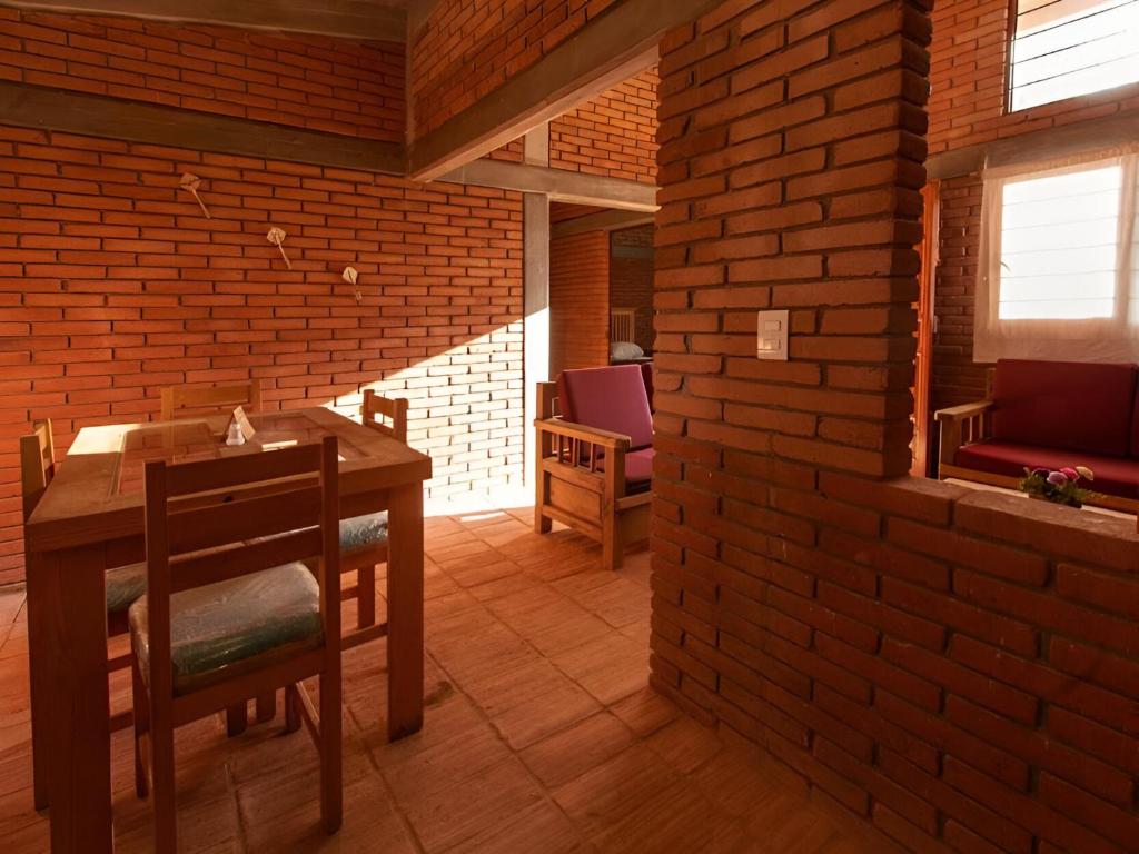 a dining room with a table and chairs and a brick wall at Hotel Casa San Pablo in Oaxaca City