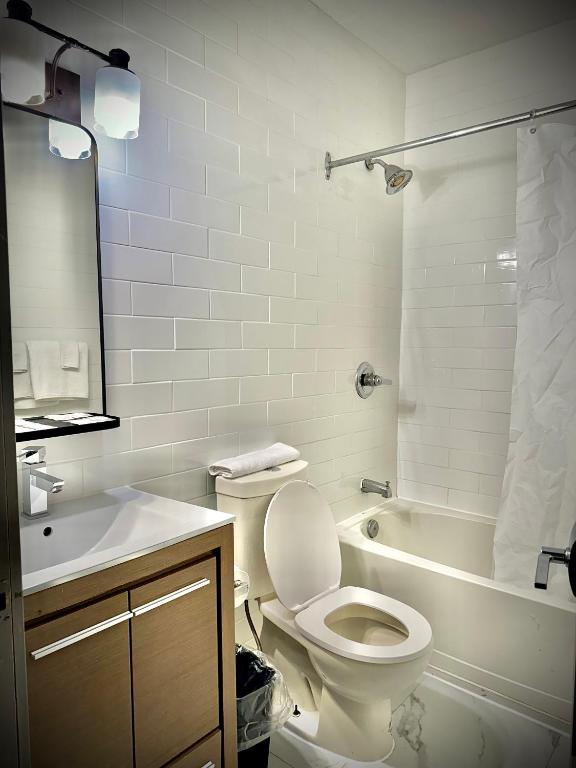 a bathroom with a toilet and a tub and a sink at Royal Oak Inn in Toronto