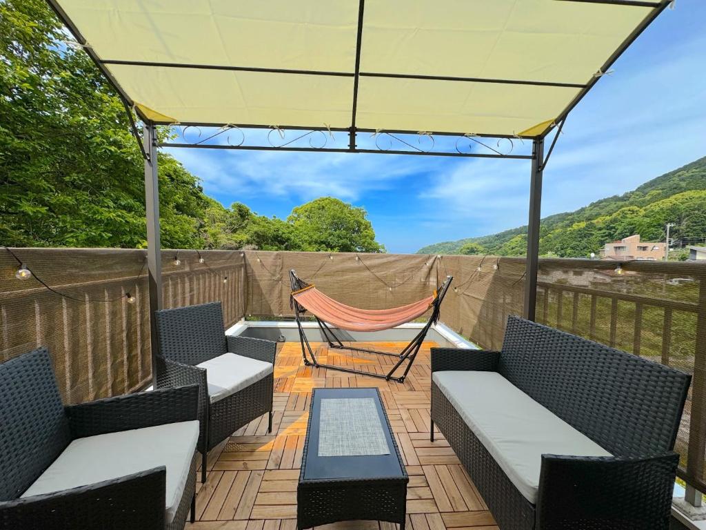 a patio with chairs and a hammock on a deck at ANGO ATAMI 3 - Vacation STAY 37803v in Atami