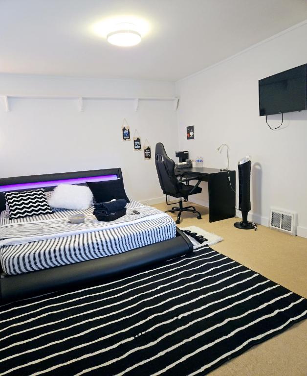 a bedroom with a bed and a desk and a chair at Comfy Stylish Room in the Heart of Vancouver- Private Parking, Self Check-in & just 4 mins to Metrotown! in Vancouver