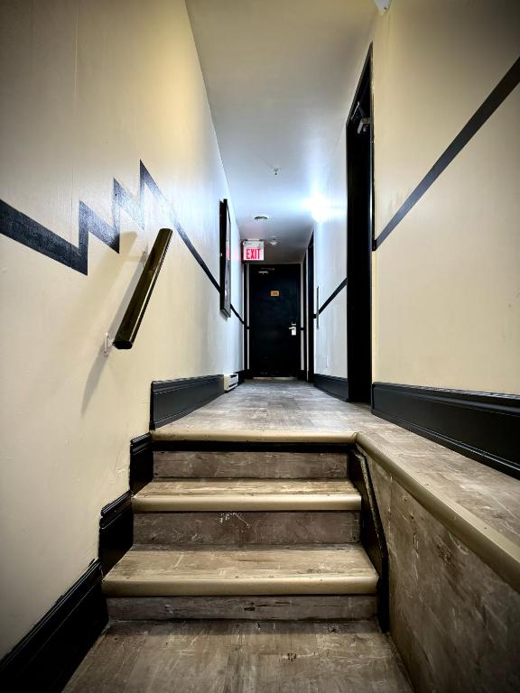 a hallway with stairs in a building with a door at Royal Oak Inn in Toronto