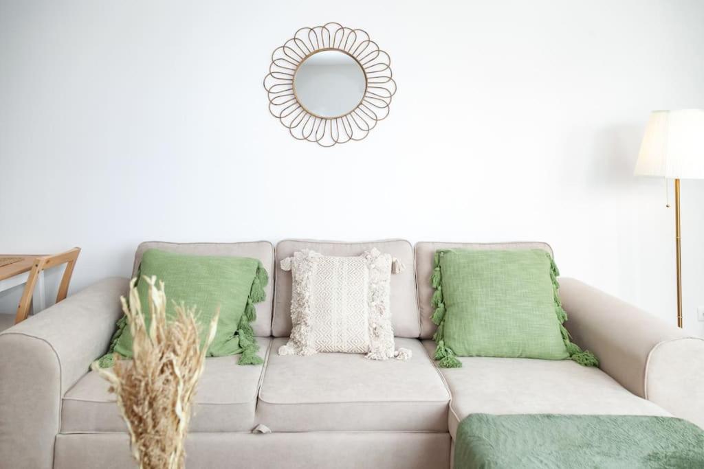 - un salon avec un canapé gris et des oreillers verts dans l'établissement Cosy F2 à Bondy, à Bondy